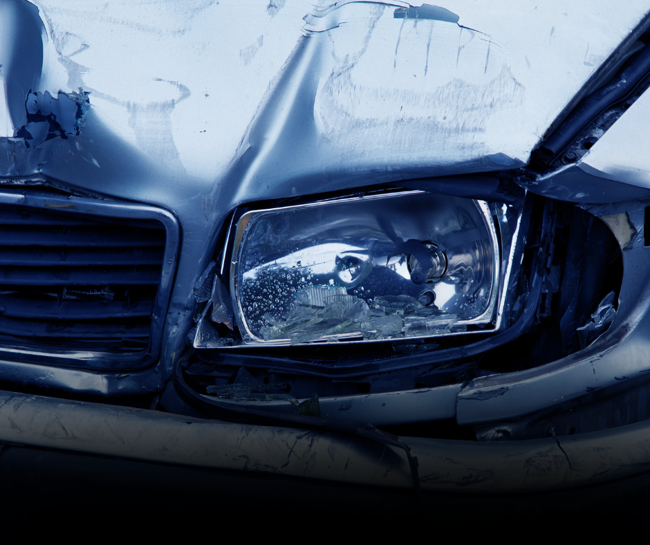 Damaged Car Front End Close-up of a damaged car headlight and fender with visible scratches and dents.